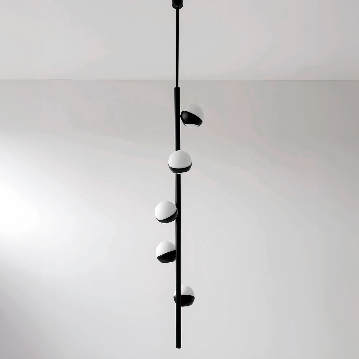 CRYSTAL TUBE lampada a sospensione moderna in ottone nero con 5 sfere di vetro Murano bianche, vista frontale completa.